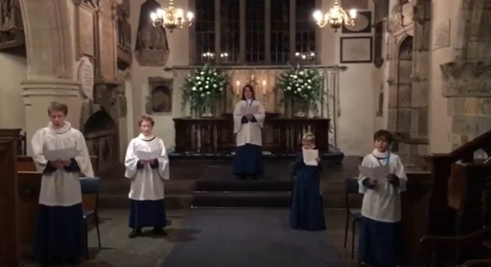 Children standing in Church holding music and singing