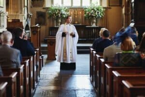 vicar standing at front of church facing congr=egation