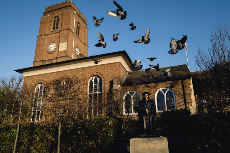 Thomas More statue with birds in flight, outside Chelsea Old Church