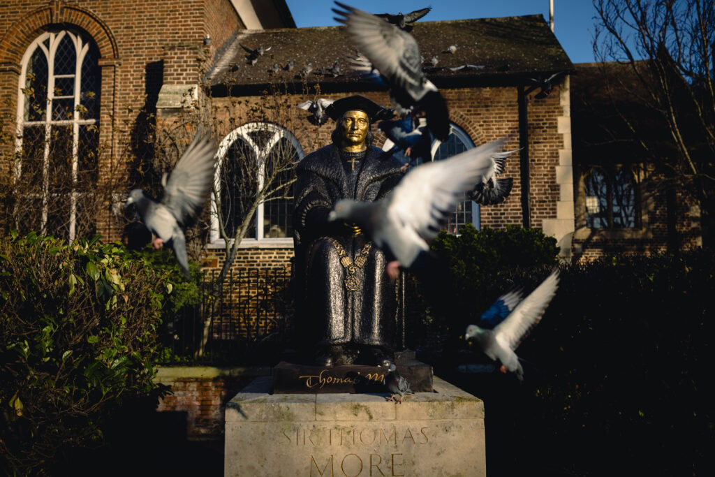 Thomas More statue with birds in flight, outside Chelsea Old Church