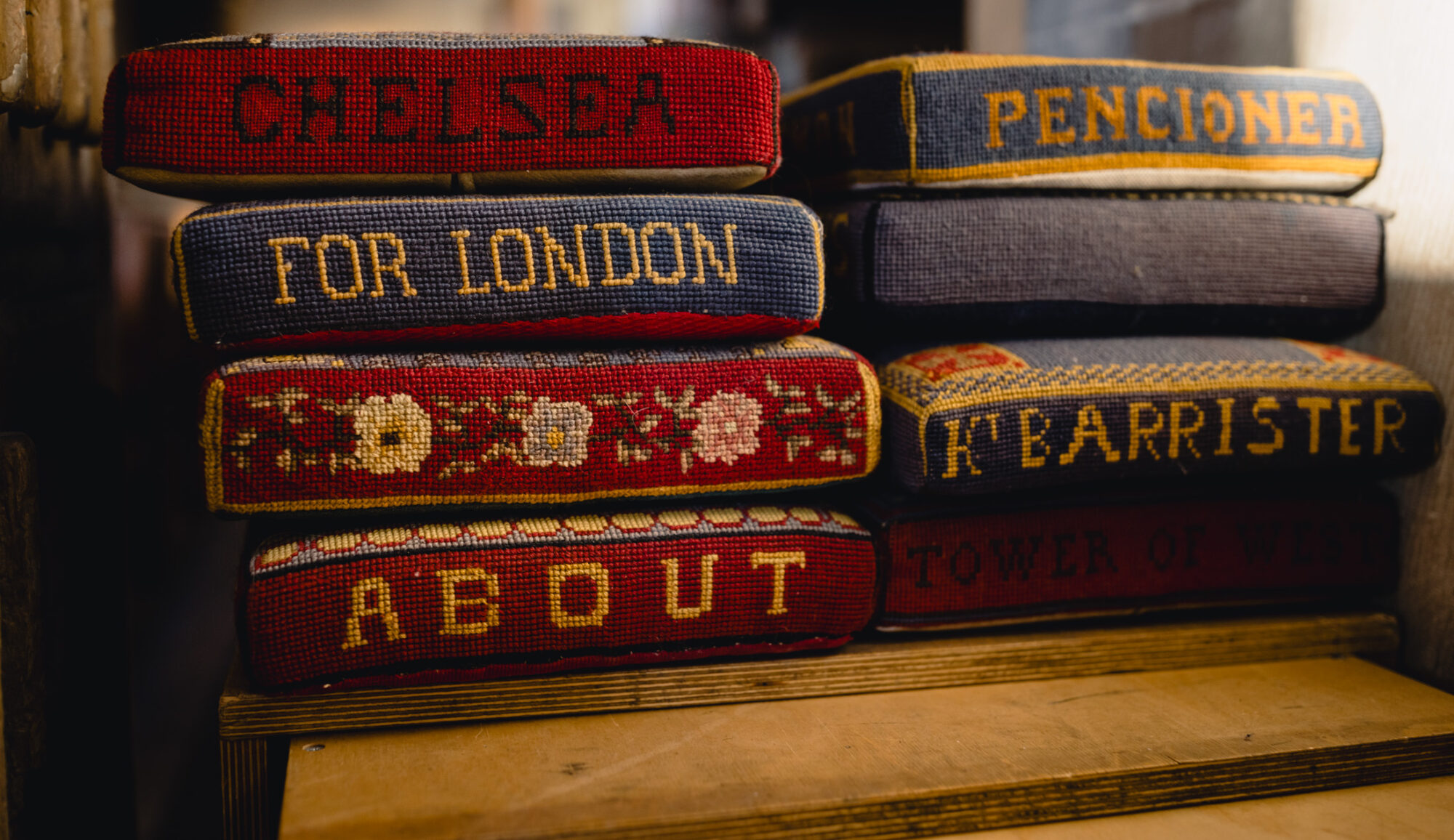 Kneelers (cushions to kneel on) with intricate stitching of flowers and words.